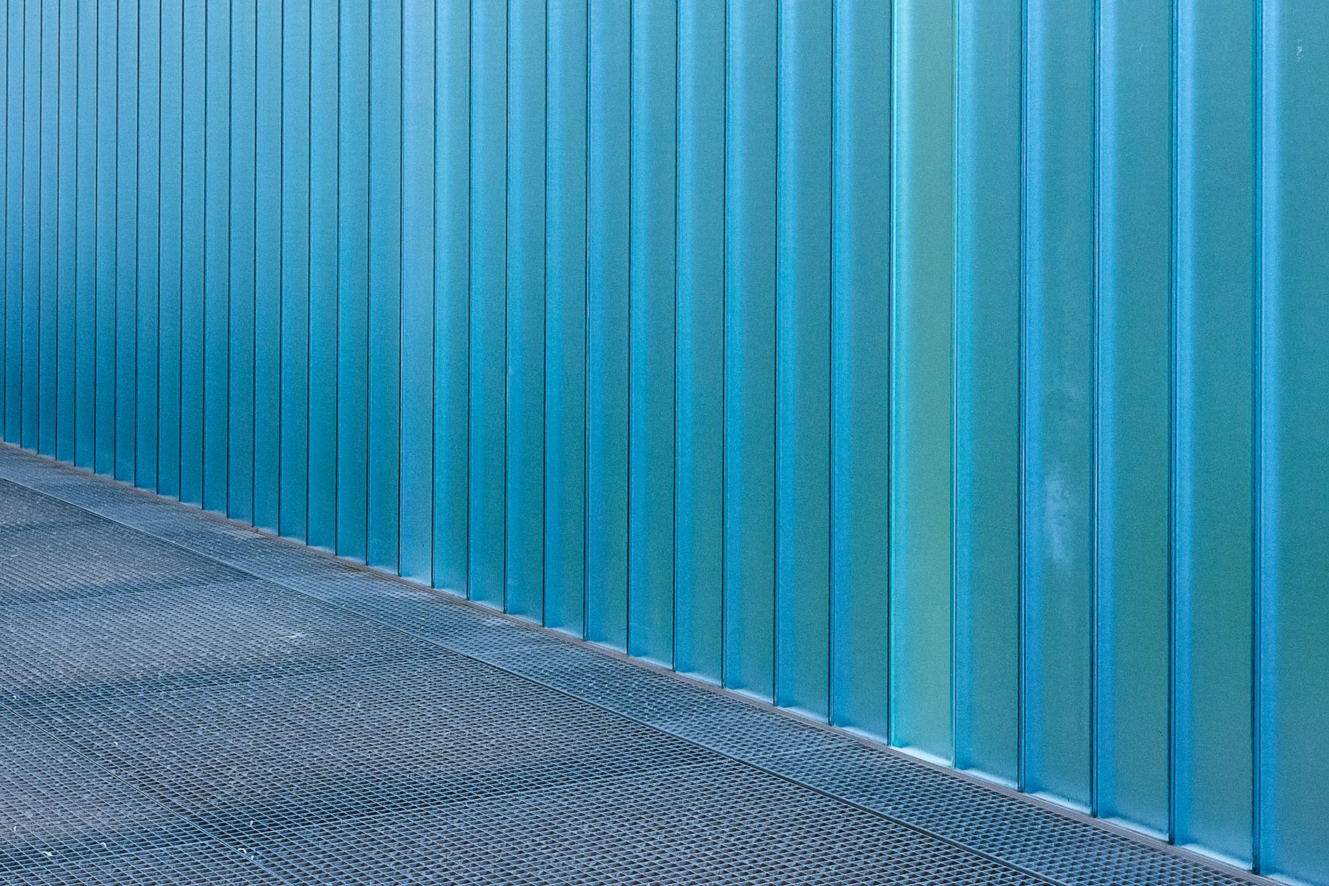 Niebieska aluminiowa ściana panelowa na tle betonowej posadzki