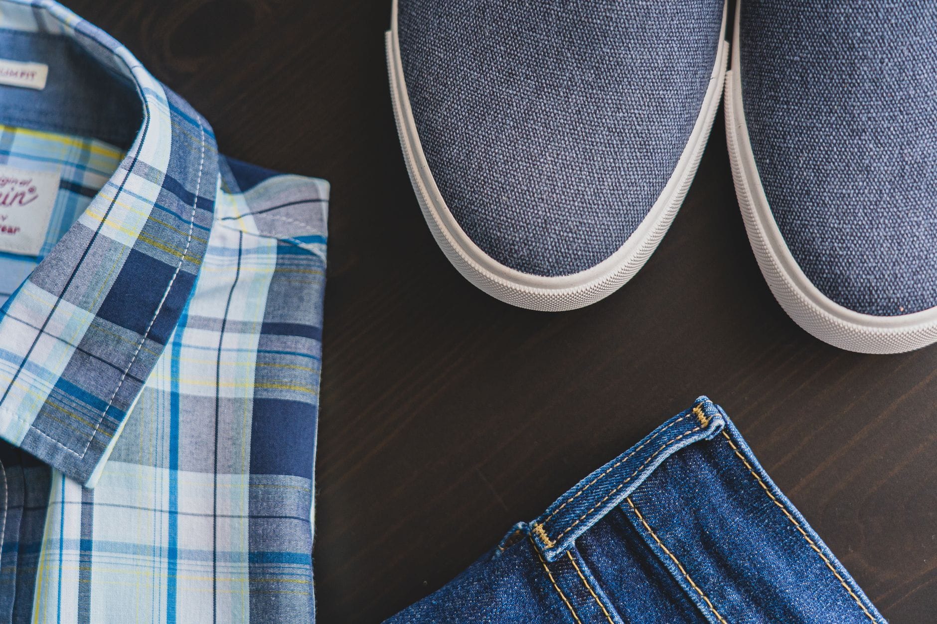 Jak zbudować męską garderobę kapsułową: kluczowe ubrania, buty i kolory na cały rok Casualowy męski zestaw: koszula w kratę, dżinsy i niebieskie sneakersy
