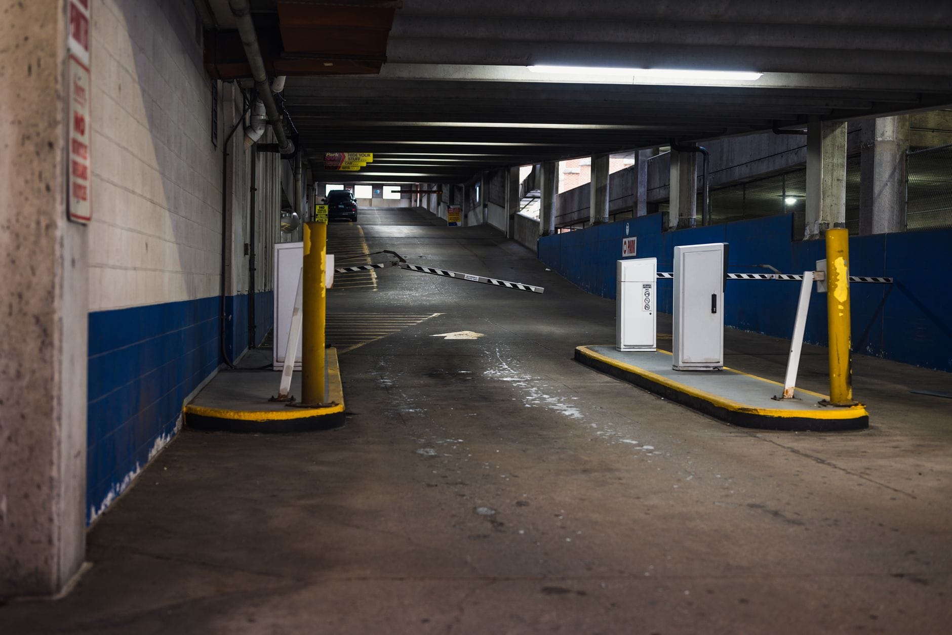 Zjazd do podziemnego parkingu z szlabanem w miejskiej zabudowie
